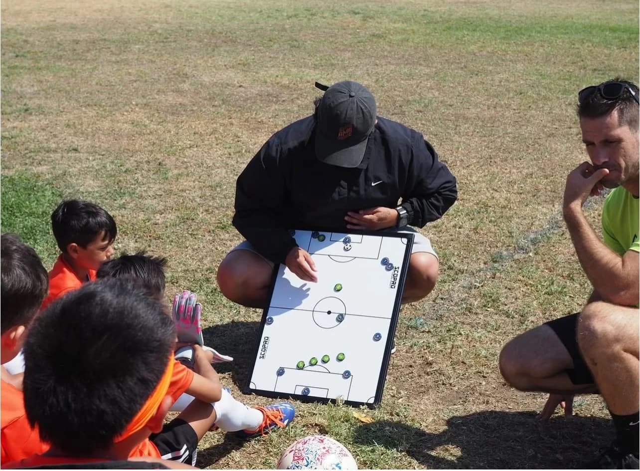 A coach drawing a play on a SCOPRO board for his youth team